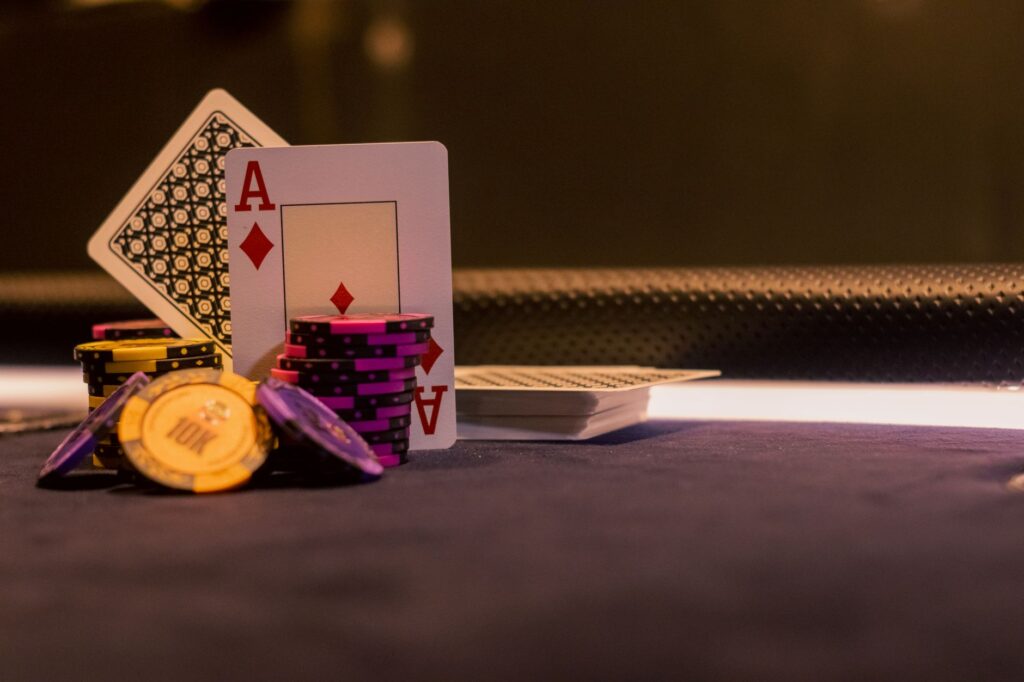 Stacked poker chips and playing cards under low light