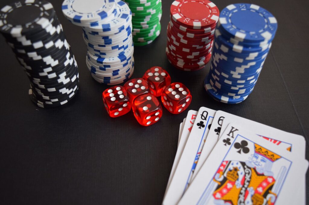 Casino chips and playing cards lit by dim neon light