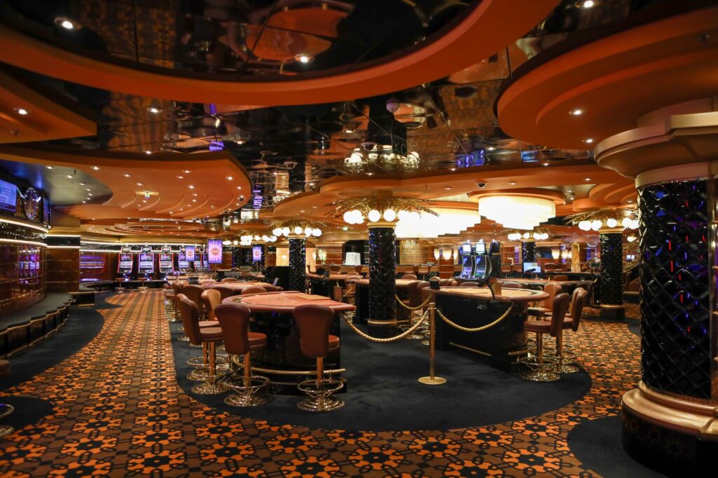 Ornate casino hall with roulette tables and warm ambient lighting