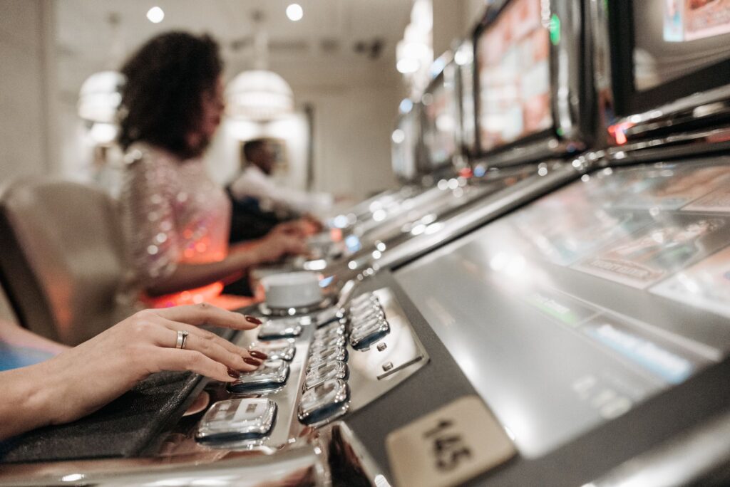 Close-up of hand pressing buttons on a slot machine panel