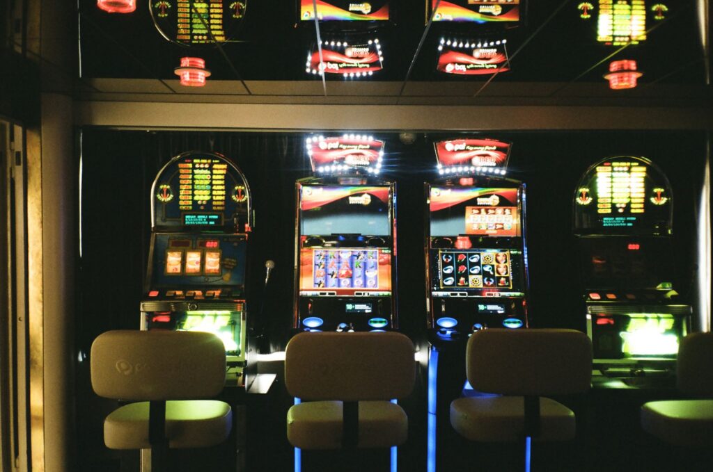 Rows of glowing casino game screens in a dim arcade setting