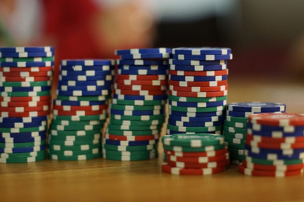 Stacked poker chips and cards on a dark table under low light
