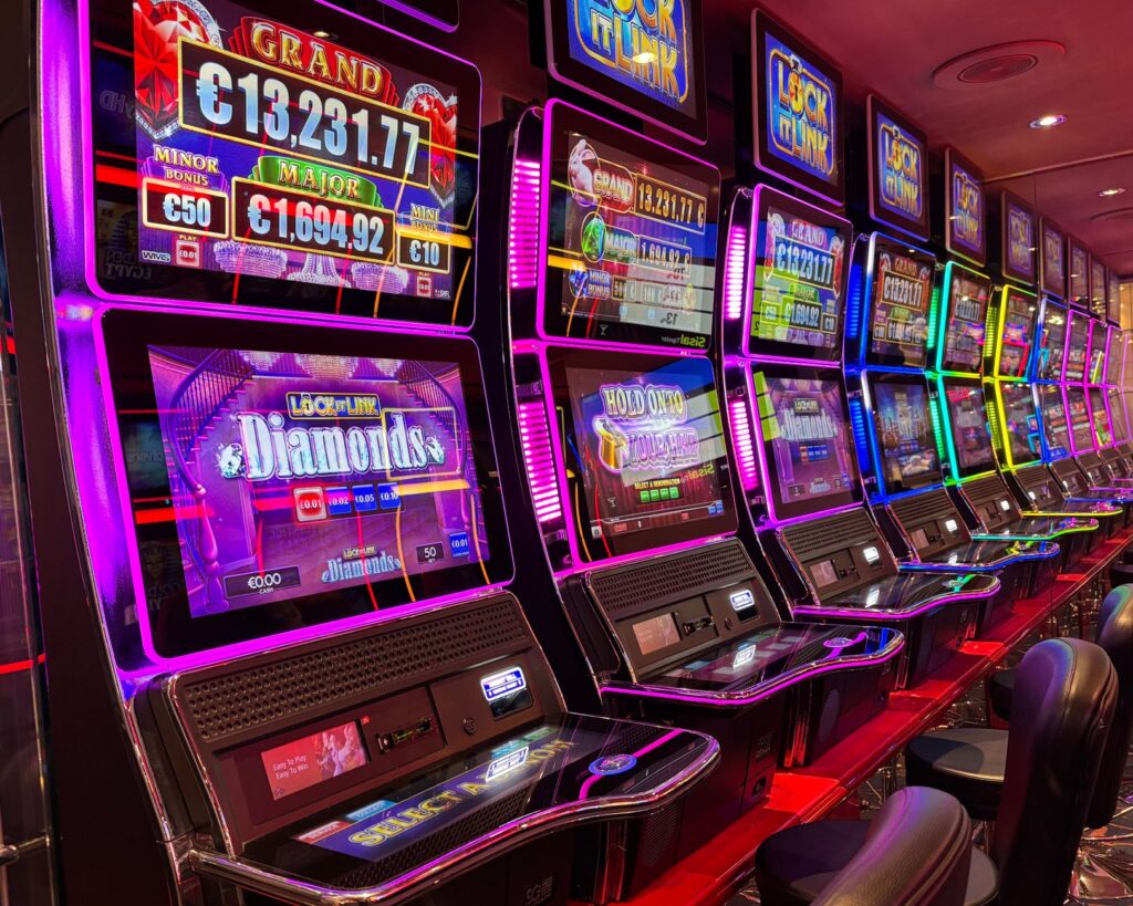 Row of illuminated slot machines with neon lights in a dim casino