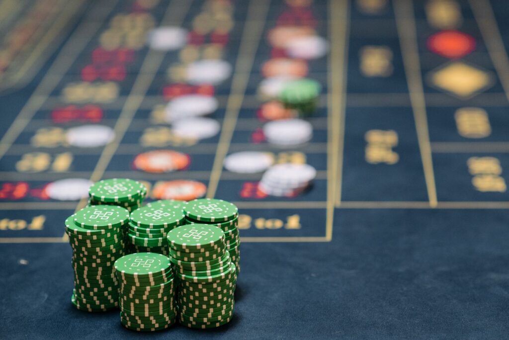 Casino chips and cards scattered on a shadowy table under low light