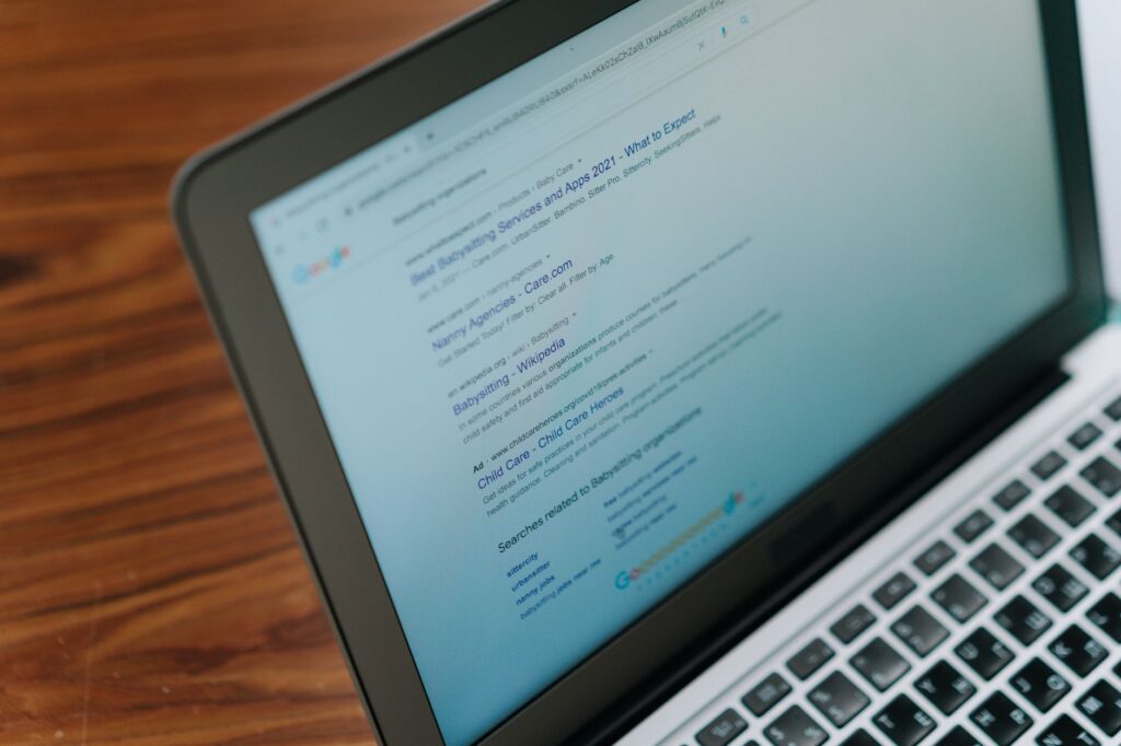 Laptop screen showing search engine results on a wooden desk