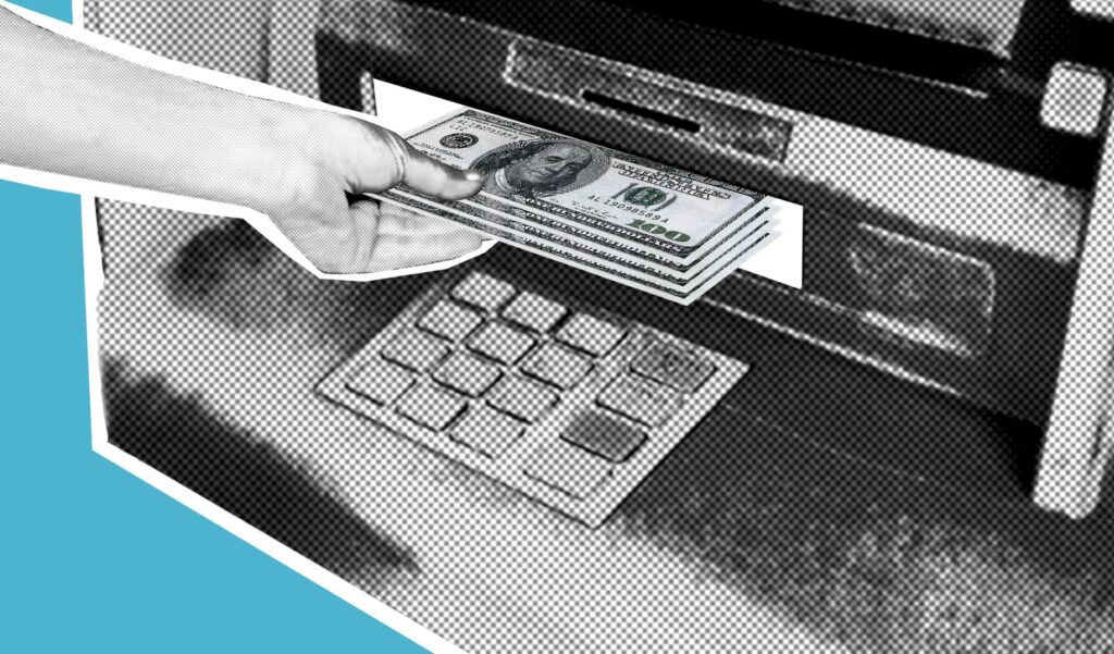 Hands withdrawing cash from an ATM at night