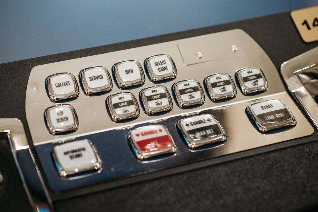 Close-up of a casino machine's metallic control panel with labeled buttons